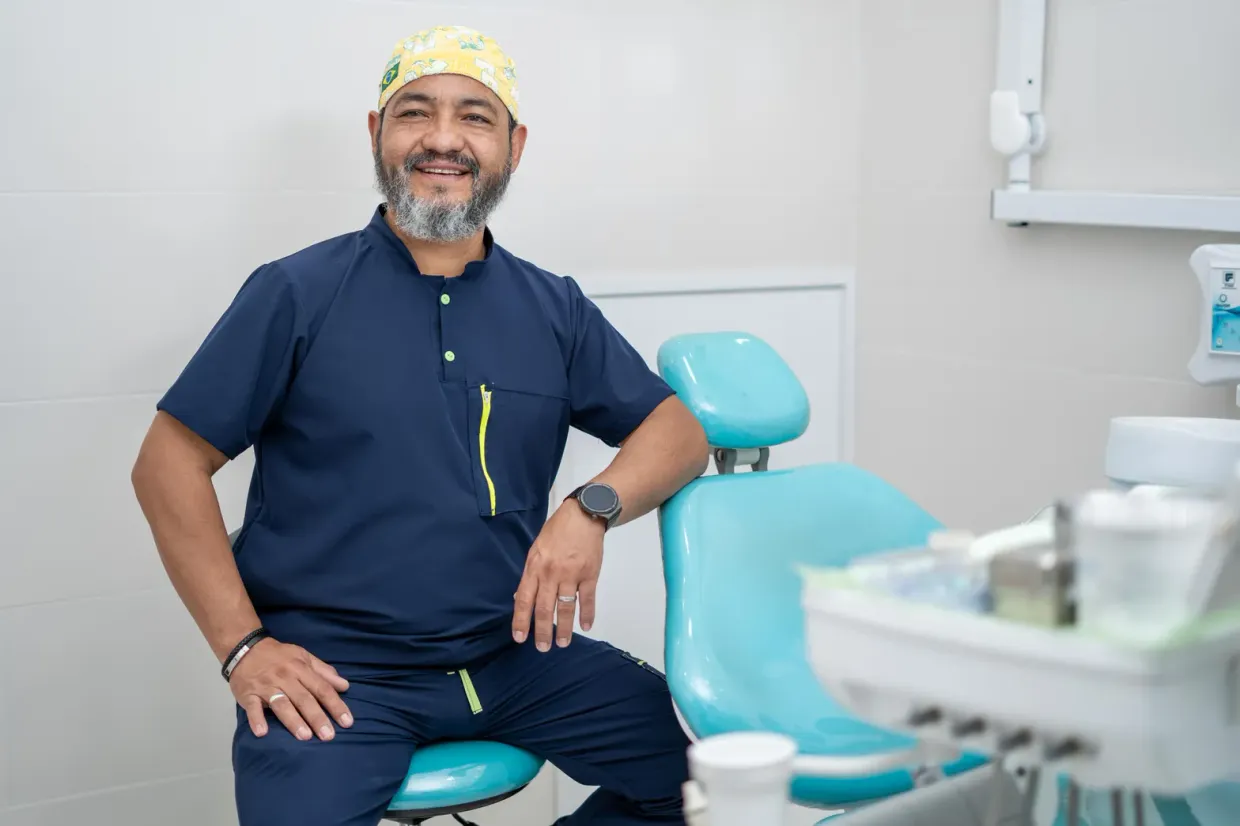 Dr. Cristián Romero sonriendo en el consultorio Saludental